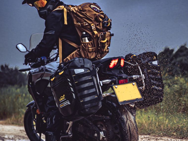 Rider on a loaded adventure bike in the mud